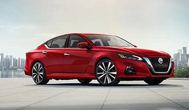 2023 Nissan Altima in red with city in background illustrating last year's 2022 model in Passport Nissan Alexandria in Alexandria VA